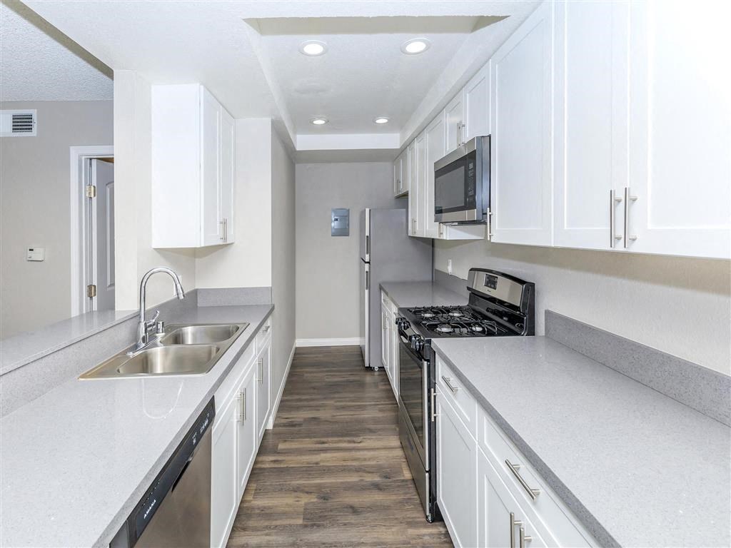 a kitchen with white cabinets and a sink and a microwave