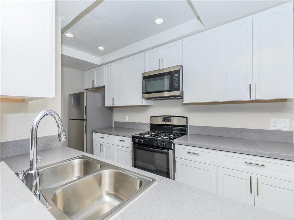 a kitchen with white cabinets and a sink