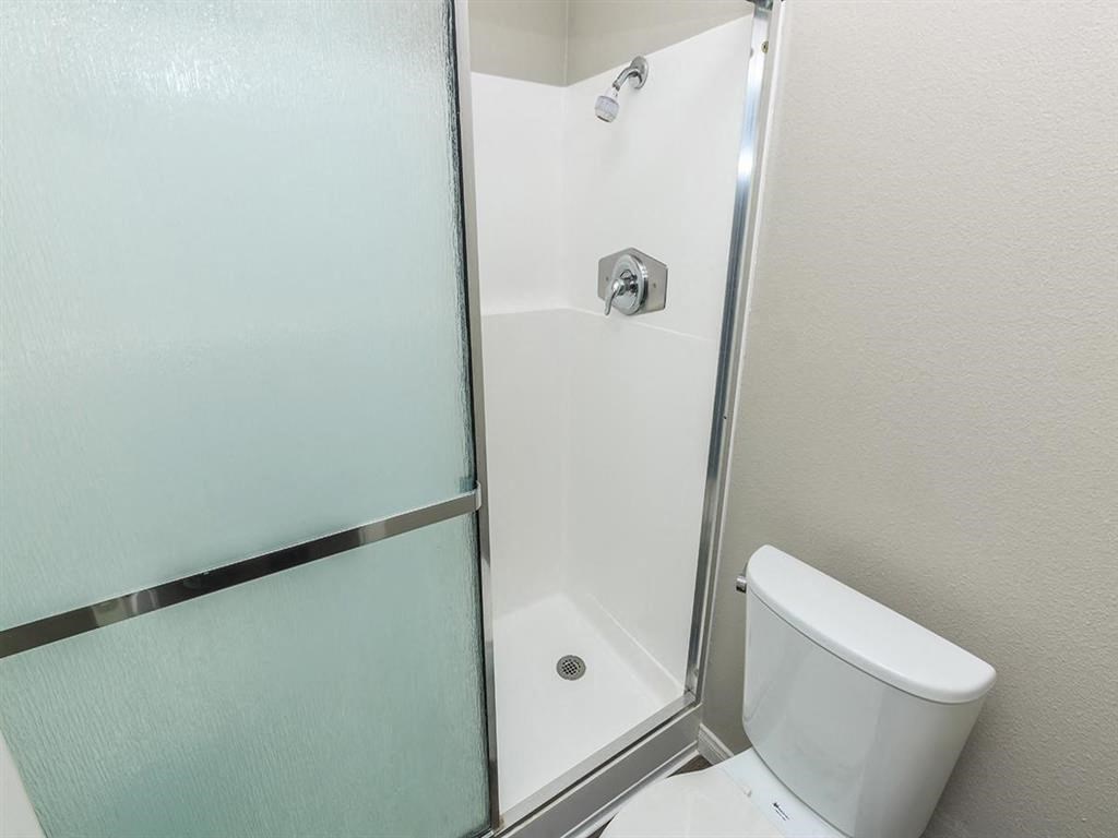 a bathroom with a toilet and a shower