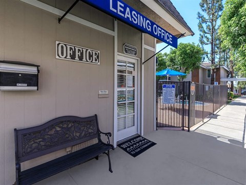 the entrance to the leasing office with a bench and a gate
