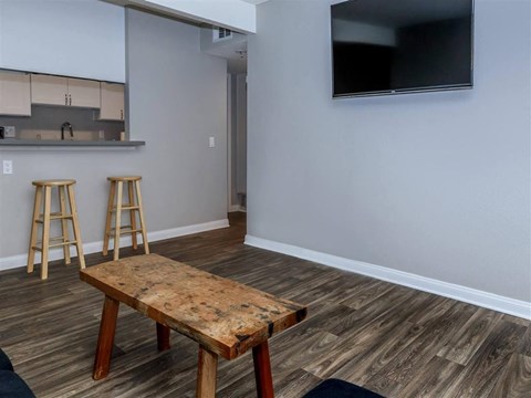 a living room with a table and two bar stools