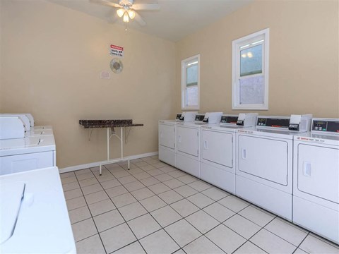 a laundry room with many washes and dryers