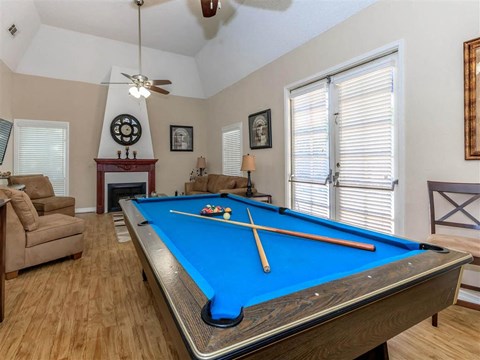 a pool table in a living room with a couch