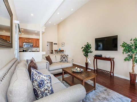 A living room with a grey couch and a wooden coffee table.