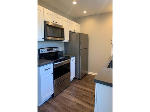 A kitchen with white cabinets and stainless steel appliances.