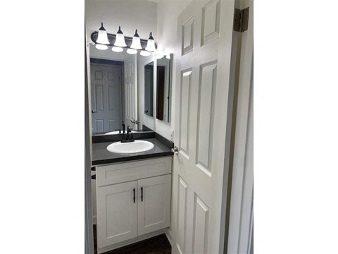 A bathroom with a sink and mirror.
