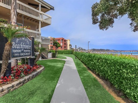A sign for Beachfront Townehomes - Renters is in front of a building.