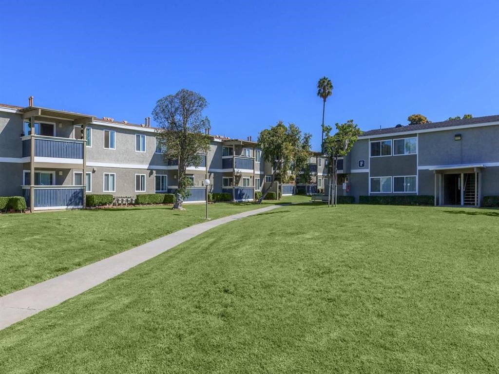 a green lawn in front of an apartment building