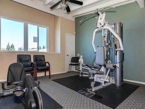 a gym with a exercise bike and chairs