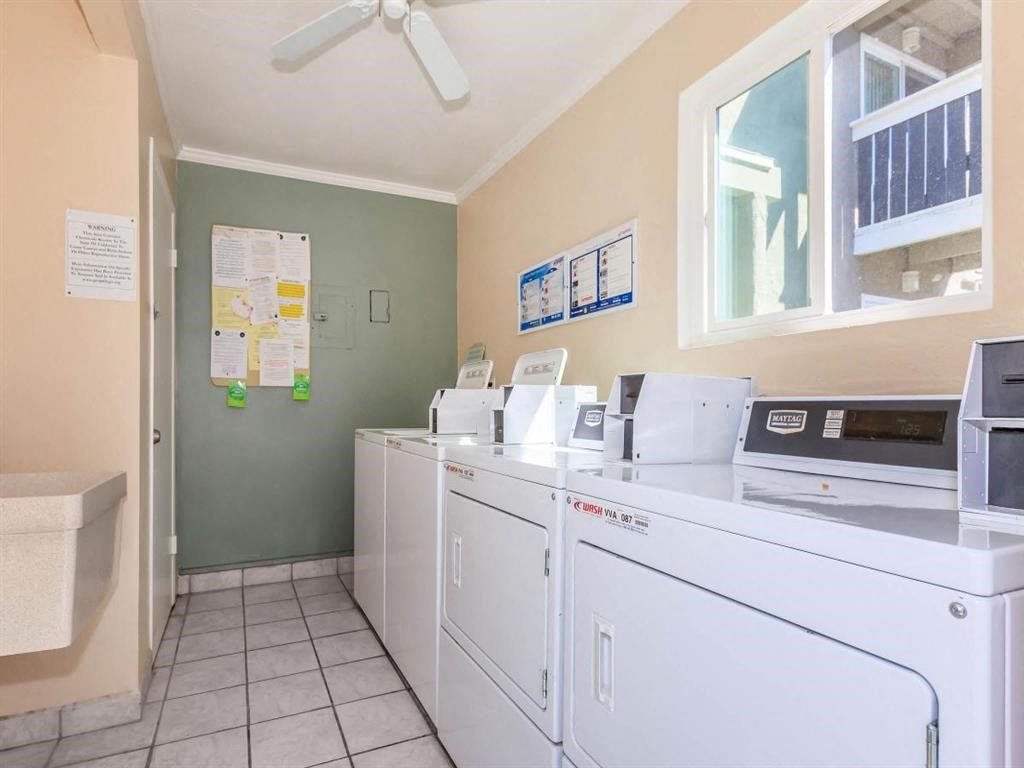 a laundry room with washes and dryers and a window
