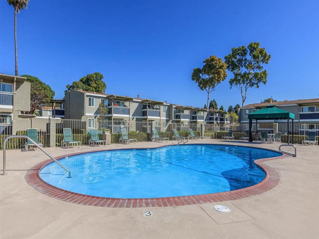 a resort style pool with apartments in the background