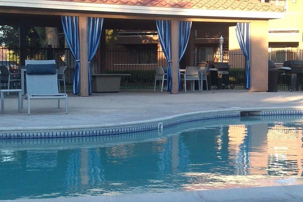 the pool area of a resort with chairs and a pool