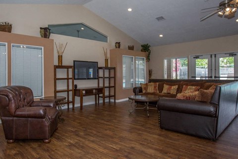 A living room with brown leather furniture and a flat screen TV.