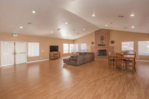 A spacious living room with a fireplace and a dining table set up.