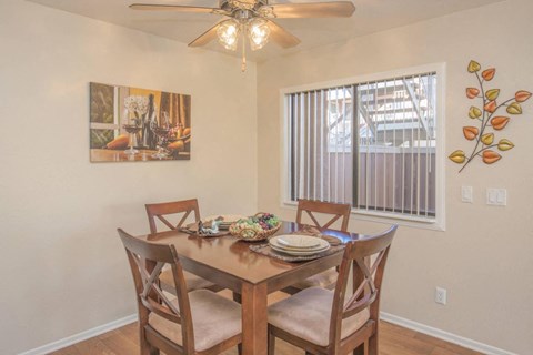 A dining room with a table set for four.