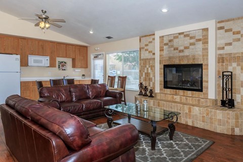 A living room with brown leather couches and a glass coffee table.