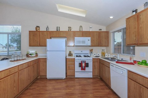 A kitchen with wooden cabinets and white appliances.
