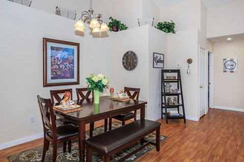 A dining room with a wooden table and chairs.