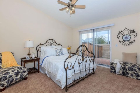 A bedroom with a large bed and a ceiling fan.