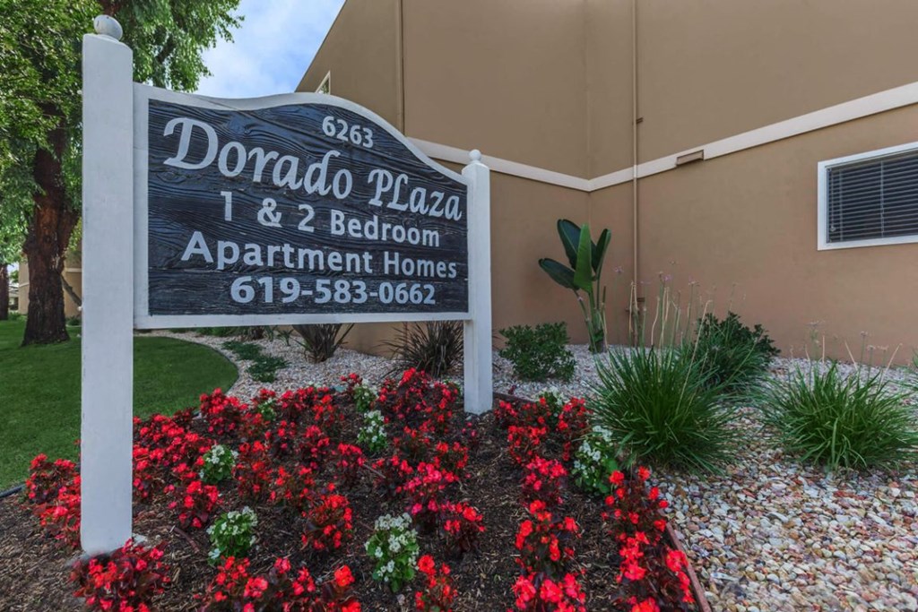 a sign in front of a building with flowers