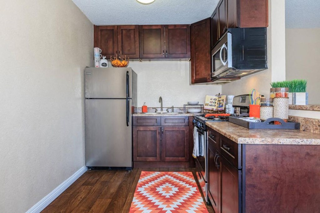 a small kitchen with a stainless steel refrigerator