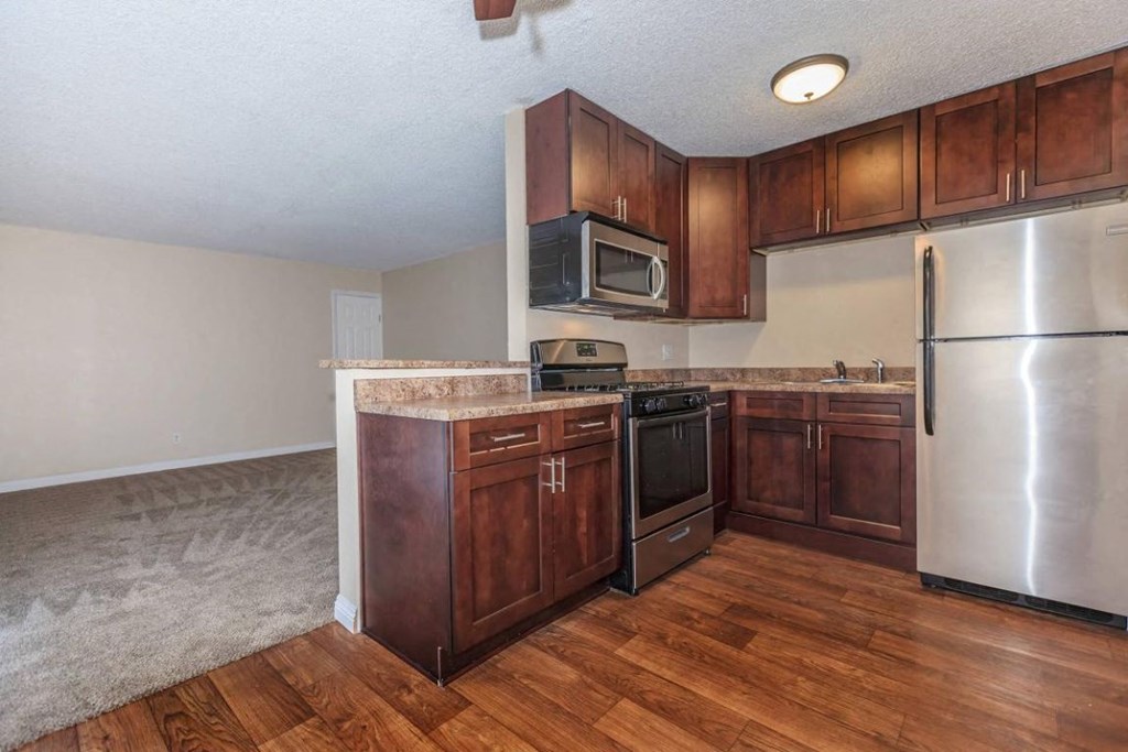 a kitchen with wooden cabinets and stainless steel appliances