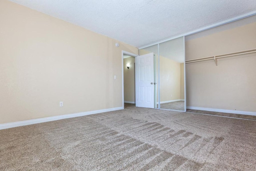 an empty living room with a door to a closet