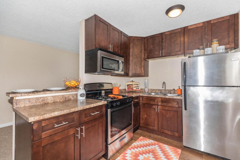 a kitchen with stainless steel appliances and wooden cabinets