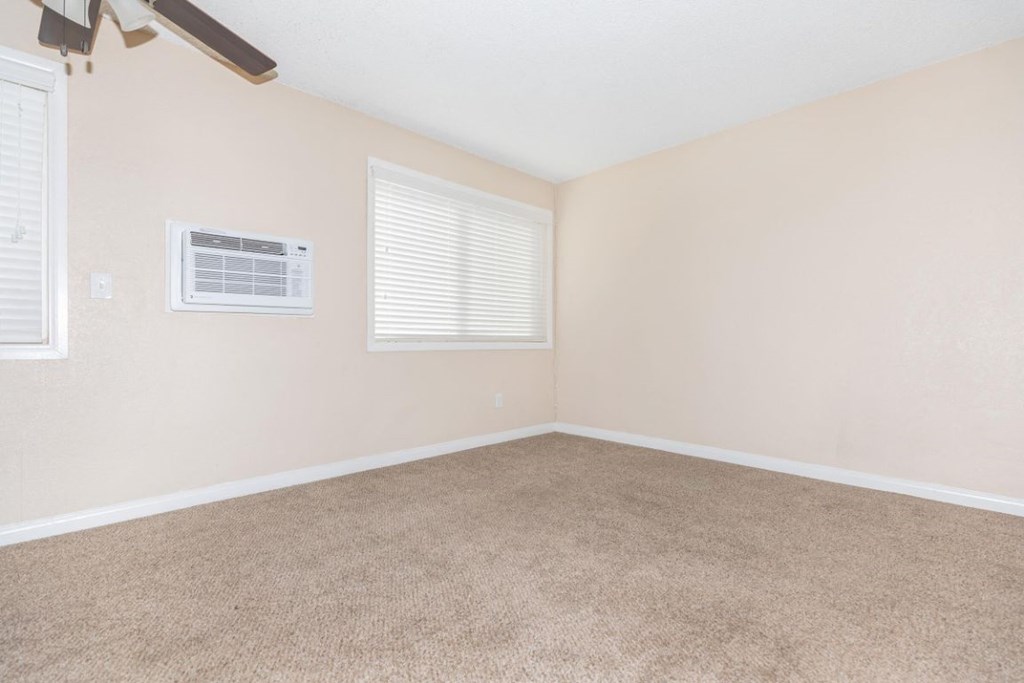 an empty living room with a heater in the corner