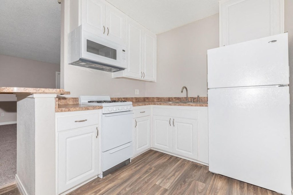 a kitchen with white cabinets and a white refrigerator