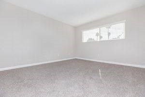 an empty bedroom with a window in the wall