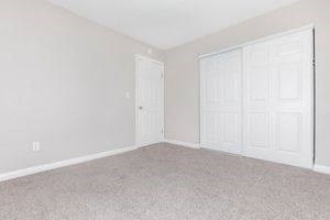 an empty bedroom with two white doors