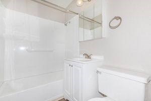 a white bathroom with a toilet and a sink