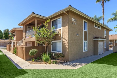 A beige two-story apartment building with the number 951 on the front.