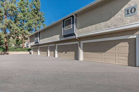 an empty parking lot in front of a building with garage doors