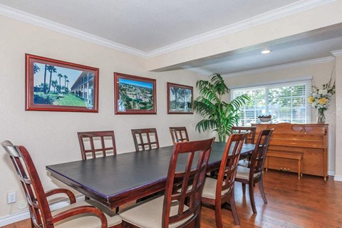 A dining room with a table and chairs.