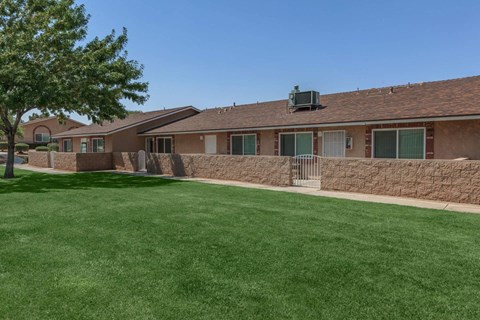 A building with a brown roof and a green lawn in front.