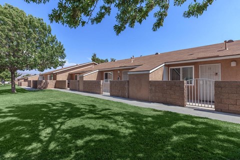 A row of houses with green lawns in front.