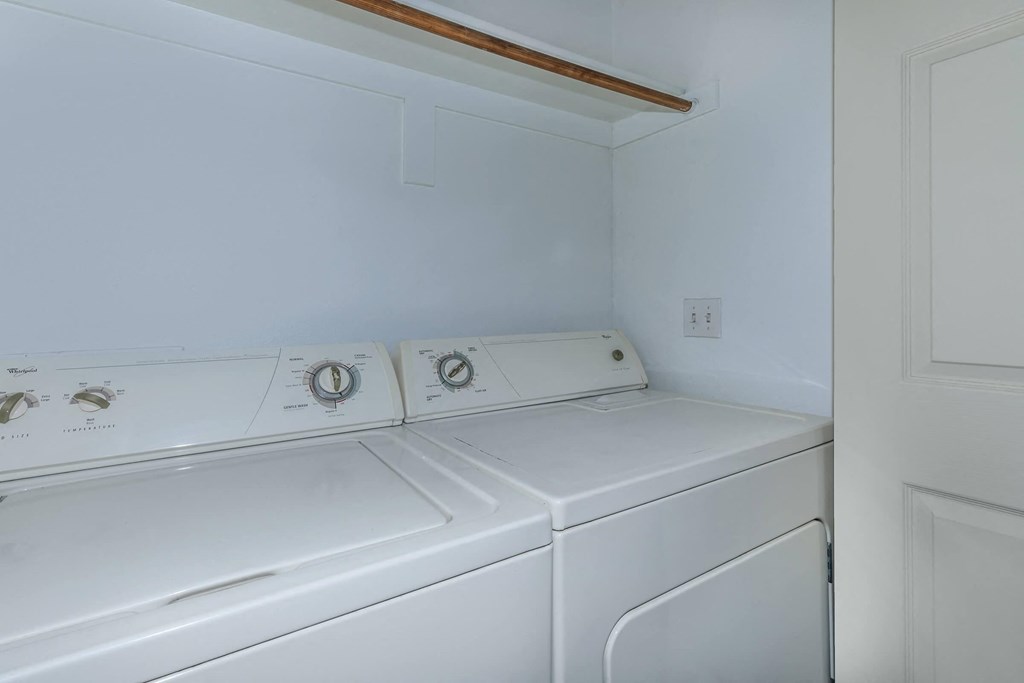 a white washer and dryer in a white laundry room