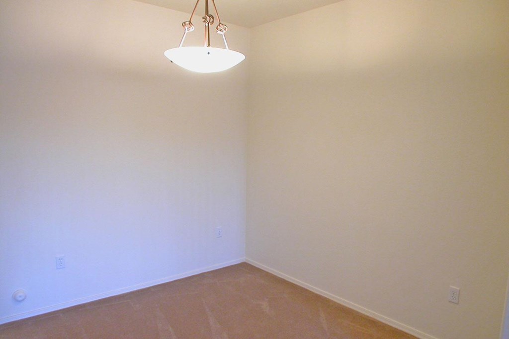 a empty room with a light hanging from the ceiling