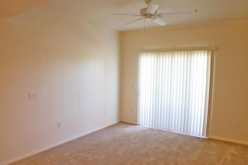 a living room with a ceiling fan and a window