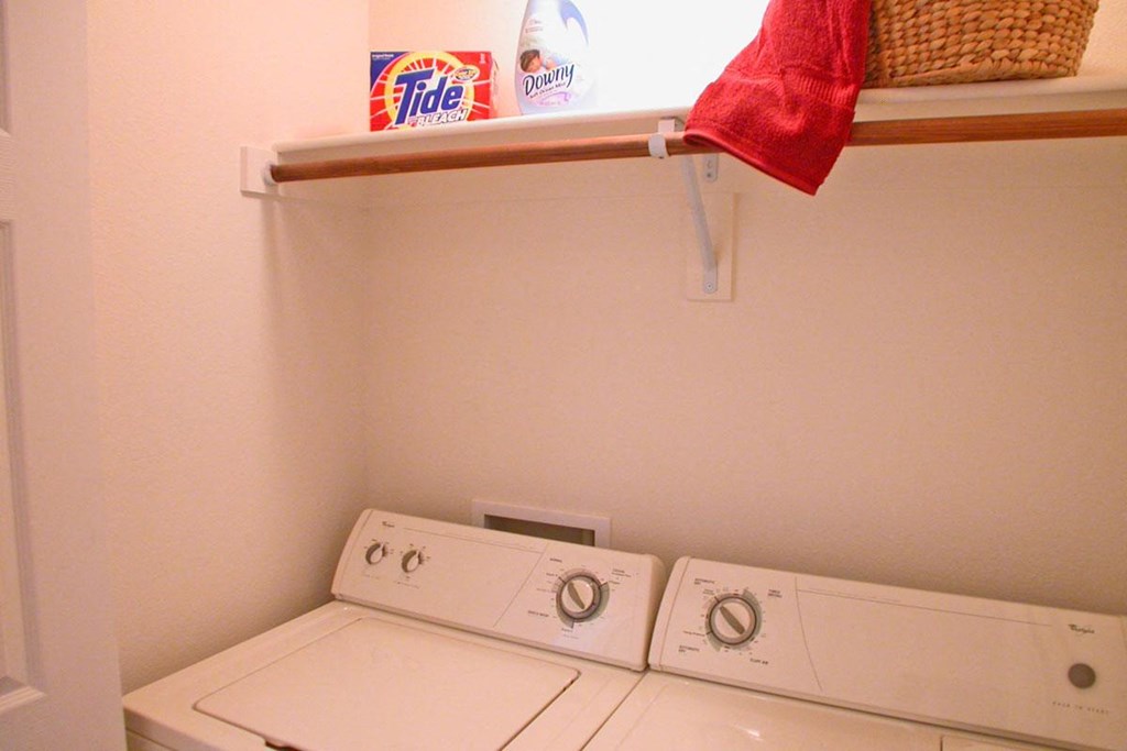 a washer and dryer in a laundry room with a shelf
