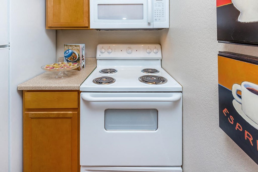 a white stove top oven in a kitchen next to a microwave