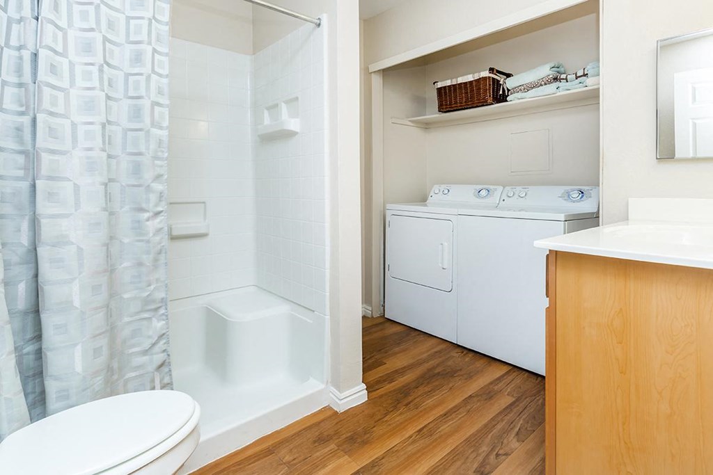 a bathroom with a washer and dryer and a shower