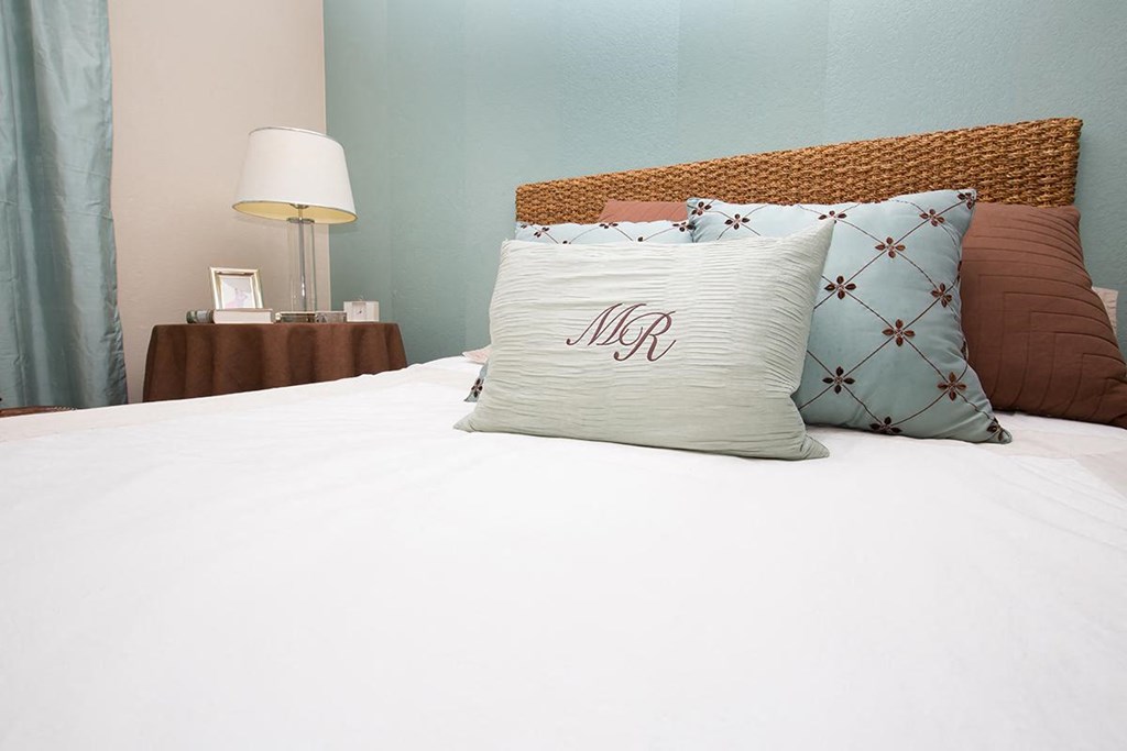 a white bed with pillows on top of it