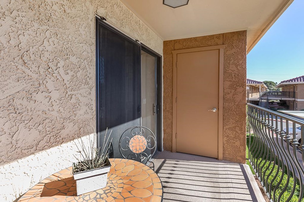 a small patio with a chair and a potted plant
