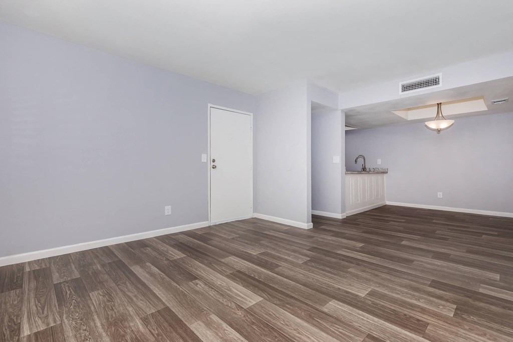 the living room and kitchen in a new home with wood flooring