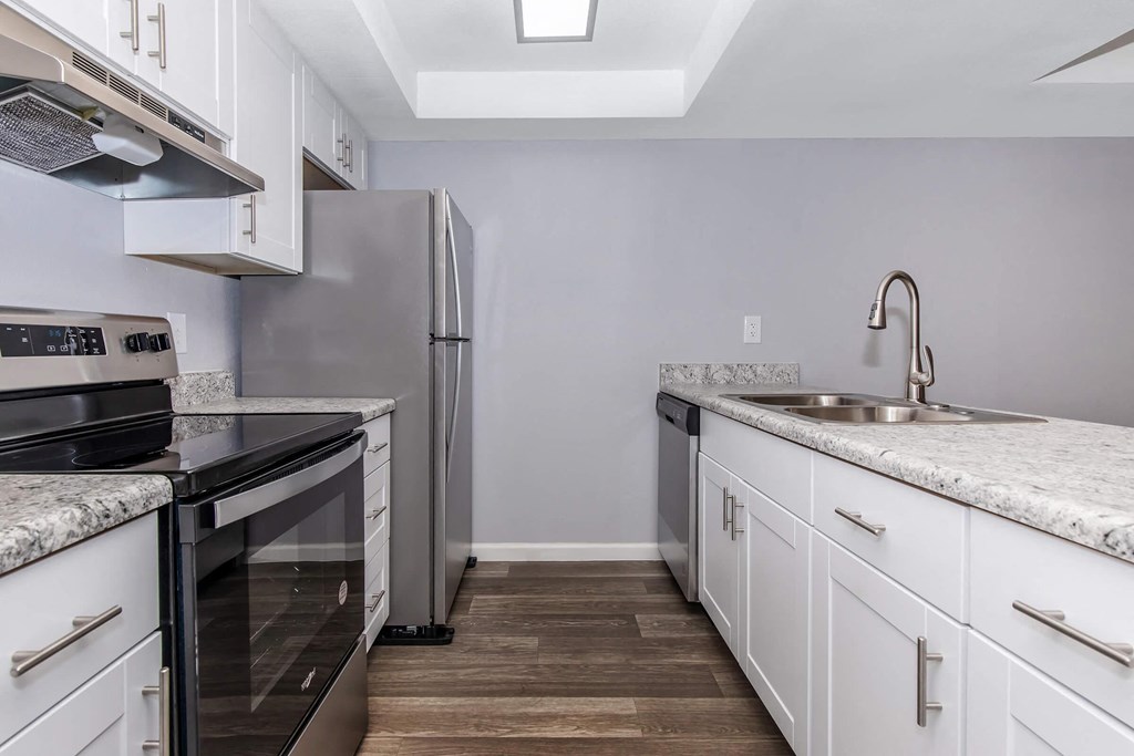 a kitchen with white cabinets and a stainless steel refrigerator
