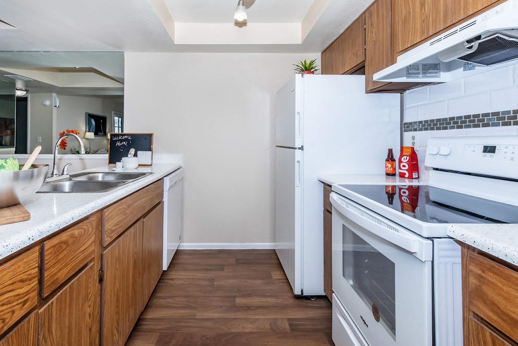 a kitchen with white appliances and wooden cabinets