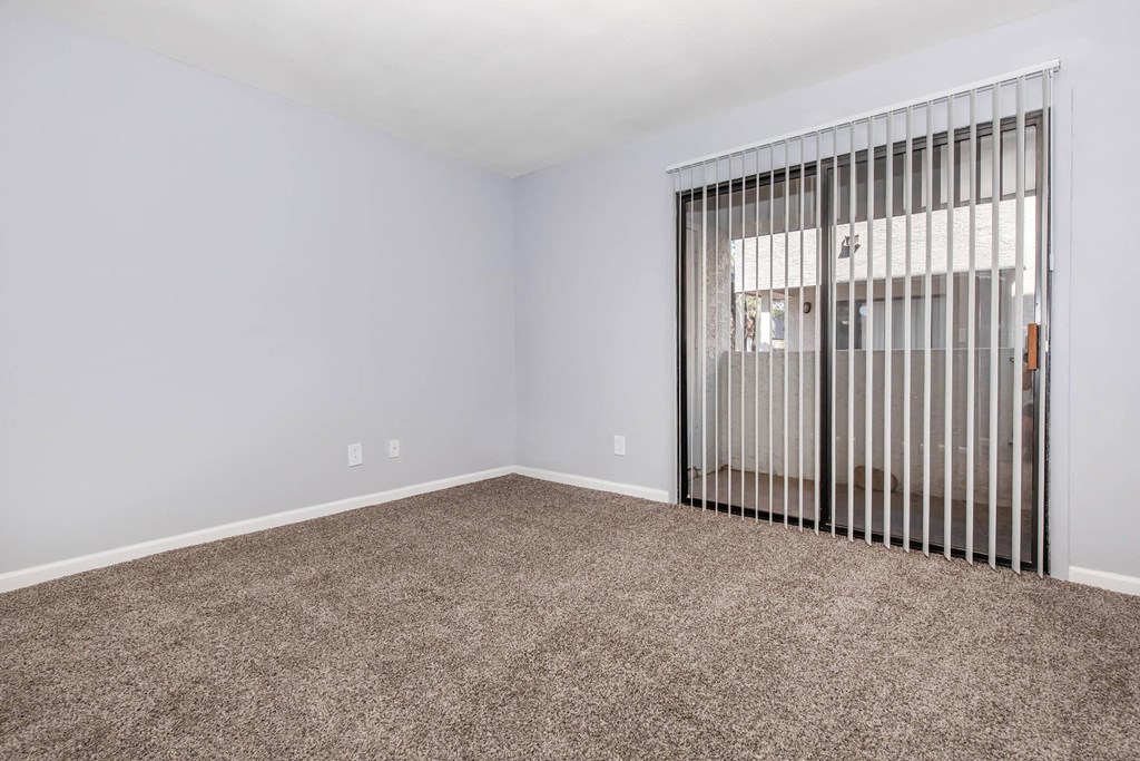 a living room with a sliding glass door and carpet